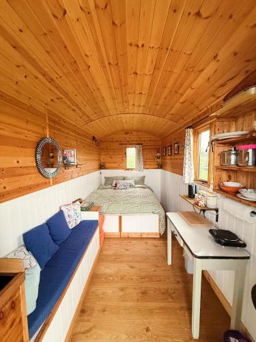 a bedroom with a bed in a wooden cabin at Herdsman's Hideaway on the Wye in Fawley Station