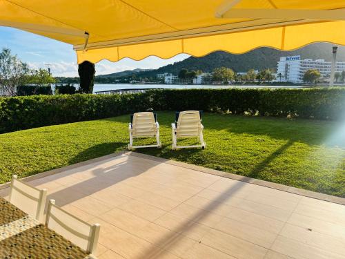 two chairs sitting under a large yellow umbrella at Villa Dulce in Port d'Alcudia