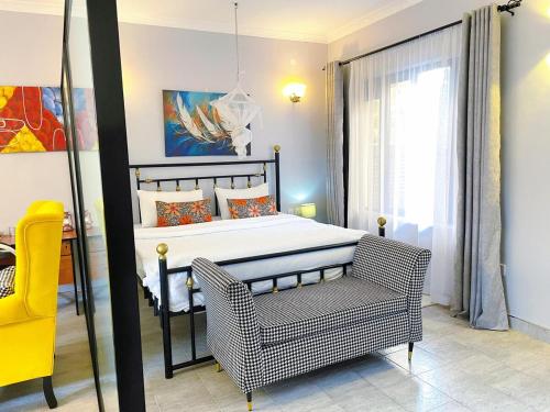 a bedroom with a bed and a chair in it at Lilac cottage in Nairobi