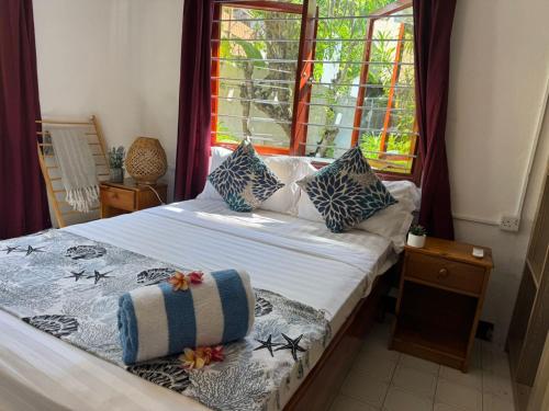 a bedroom with a bed with pillows and a window at Le Rocher De Machabee in Mahe