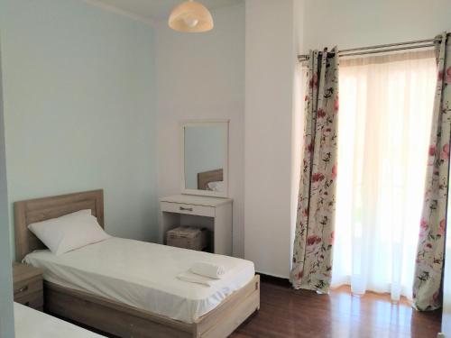 a small bedroom with a bed and a mirror at Ioannis Foteinos Studios in Lygia