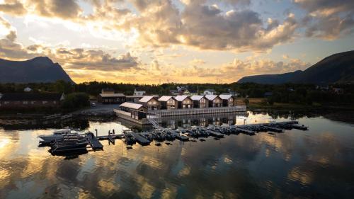 a marina with boats in the water at sunset at Risøyhamn Sjøhus AS in Risøyhamn