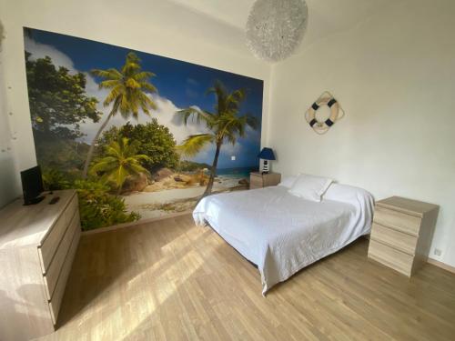 a bedroom with a bed and a painting of a beach at Le cadeau bleu, duplex en Cévennes in La GrandʼCombe