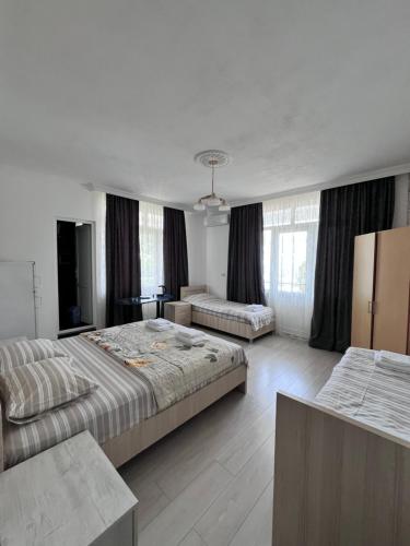 a hotel room with two beds and a couch at Zuri Kvariati in Kvariati