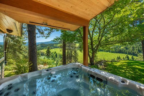 a hot tub under a wooden roof with a view at River Heights Home cabin in Leavenworth