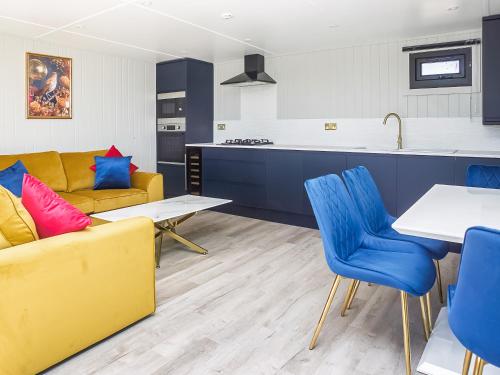 a living room with a yellow couch and blue chairs at Nightingale Lodge - Uk51938 in Yarm
