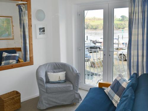 a living room with a couch and a chair and a window at Ferrydown in Salcombe