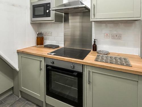 a kitchen with a counter with a stove top oven at Wolf Bear Tor in Bamford