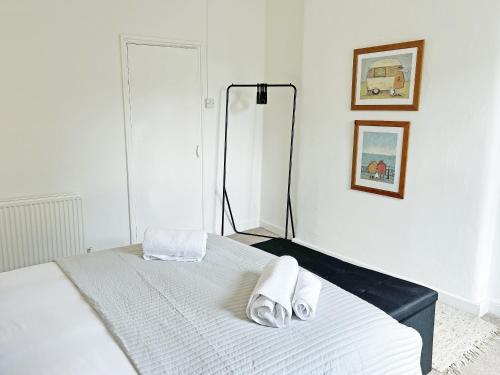 a white bedroom with a bed with towels on it at Wolf Bear Tor in Bamford