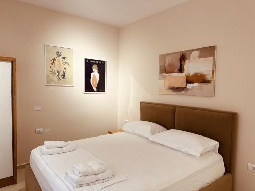 a bedroom with a bed with two towels on it at Thoma's K Studios in Vlorë