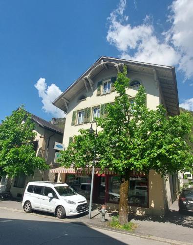 a white car parked in front of a building at Ferienwohnung Meiringen in Meiringen