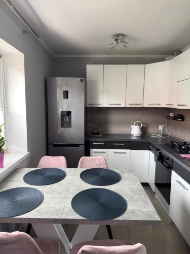 a kitchen with a table and pink chairs in it at Dom nad jeziorem in Lubkowo