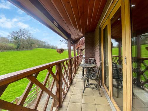 a porch of a house with chairs and a table at Maple - Uk46284 in Camerton