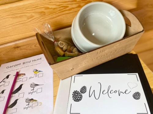 a wooden box with a welcome sign and a bowl at Apple-Uk46285 in Camerton