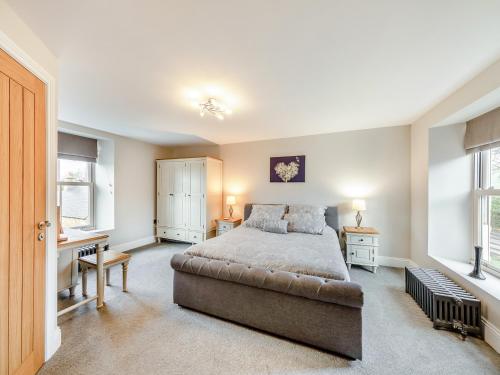a bedroom with a bed and two windows at Binchester Crag Farm in Bishop Auckland