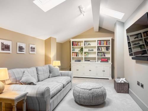 a living room with a couch and a book shelf at Cross Keys Cottage in Skipton