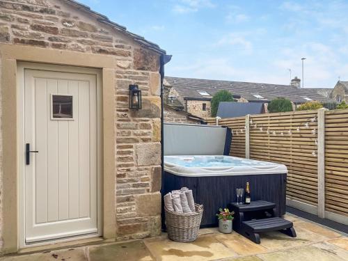 a hot tub on the patio of a house at Cross Keys Cottage in Skipton
