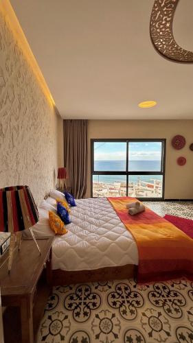 a bedroom with a large bed and a large window at Adventurekeys Surf Yoga Cowork in Taghazout