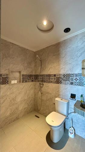 a bathroom with a toilet and a shower at Adventurekeys Surf Yoga Cowork in Taghazout