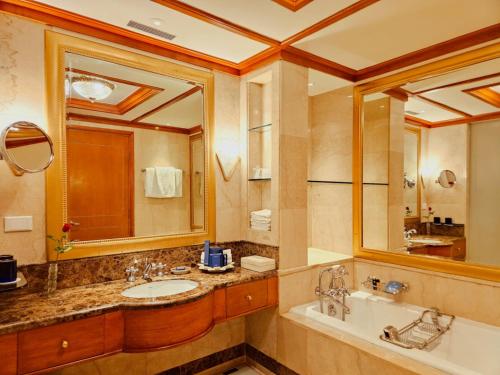 a bathroom with a sink and a large mirror at Wildflower Hall, An Oberoi Resort, Shimla in Shimla