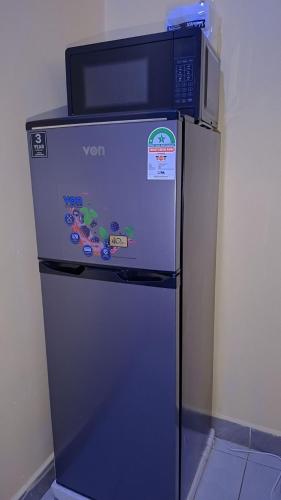 a refrigerator with a microwave on top of it at BREE'S EXECUTIVE STAYs in Kakamega