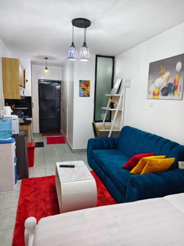 a living room with a blue couch and a red rug at GCurtway Homes Tsavo Superior Studios in Nairobi