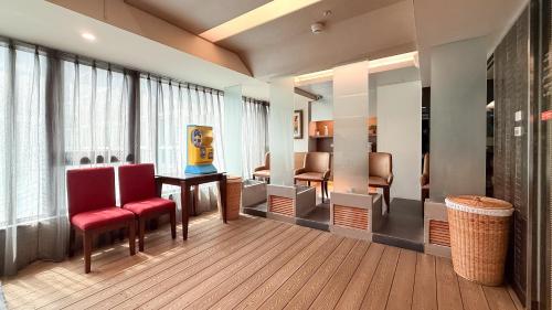 a waiting room with red chairs and a table at In One City Inn in Taichung