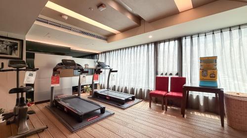 a living room with a television and red chairs at In One City Inn in Taichung
