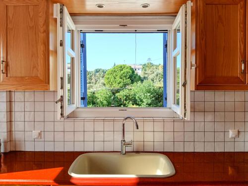 a kitchen with a sink and a window at Gaia Skiathos Apartments in Achladies