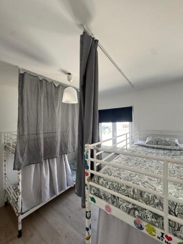 una camera da letto con due letti a castello e una finestra di 70's Hostel a Ericeira