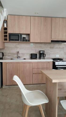 a kitchen with a white chair and a table at Duplex Atenea in Chivilcoy