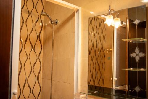 a bathroom with a shower and a mirror at Martil Plage Piscine Fibre & Netflix in Martil