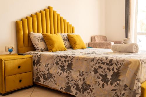 a bedroom with a large bed with a yellow headboard at Martil Plage Piscine Fibre & Netflix in Martil