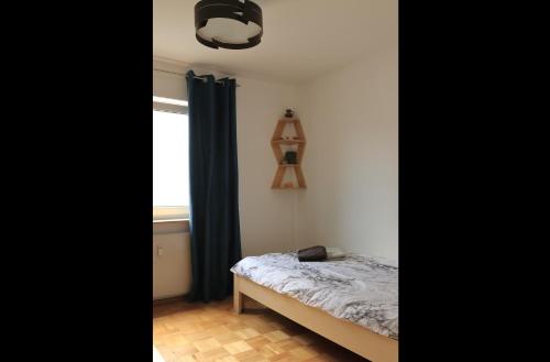 a small bedroom with a bed and a window at Heimathafen Heilbronn in Heilbronn