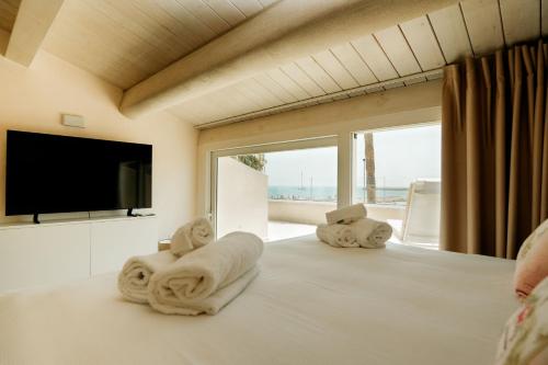 a bedroom with a bed with towels on it at Marina Homes Sea View Ortigia in Syracuse
