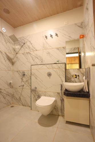 a bathroom with a toilet and a sink at hotel pride & restaurant in Dabok