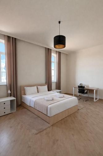 a bedroom with a large white bed and a desk at Miassine Boutique Hotel in Gyumri