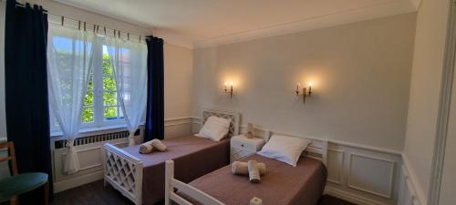 a bedroom with two beds and a window at gîte dans maison bourgeoise in Millau