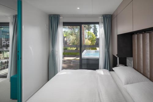 a bedroom with two beds and a view of a pool at Boutique Camping Materada Beach in Poreč