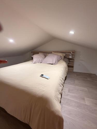 a bedroom with a bed with a remote control on it at L instant dore spa privatif in Cavaillon