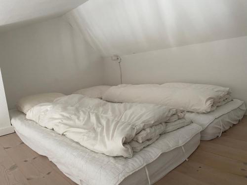 an unmade bed in a white room with at Tversted Strandpark in Bindslev