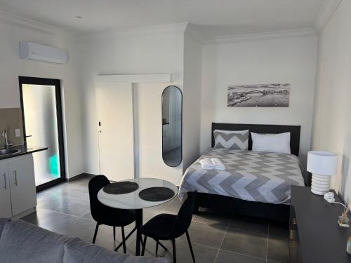 a bedroom with a bed and a table and chairs at Muzo Guest Nest in Cape Town