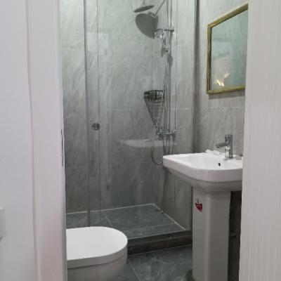 a bathroom with a shower and a toilet and a sink at TUMAR hotel in Zhezdi