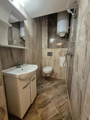 a bathroom with a sink and a toilet at Апартамент riverside in Yambol