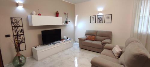 a living room with a couch and a flat screen tv at A casa di Chiara in Lecce