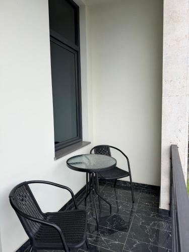 two chairs and a table in a room with a window at Hotel Elion in Yerevan