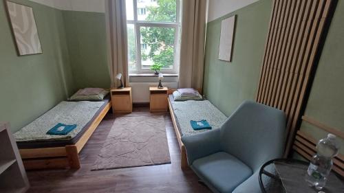 a room with two beds and a chair and a window at Ubytovaní U Dvora in Bohumín