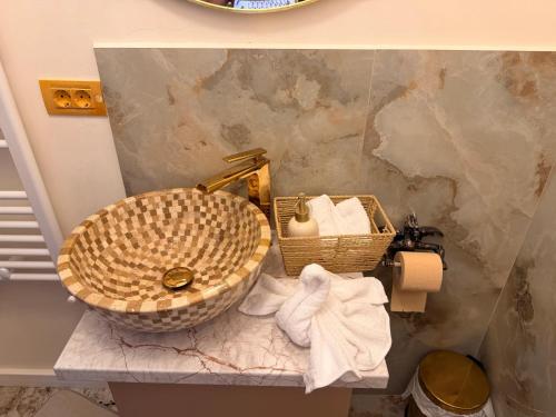 a bathroom with a sink and a basket and towels at Guesthouse Bârlogul Balaurului in Afumaţi