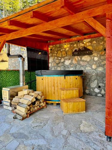 a wooden structure with a pile of fire wood at Hotel Te Liqeni in Peje