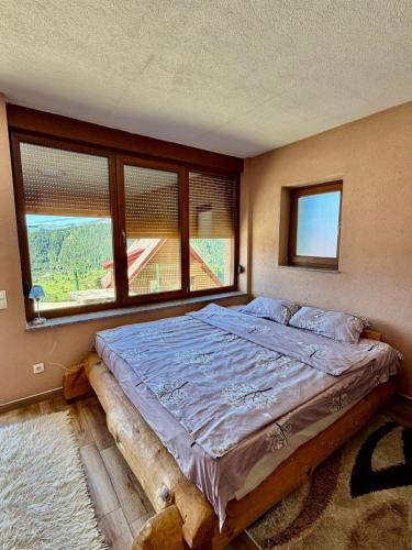 a bed in a room with a large window at Hotel Te Liqeni in Peje